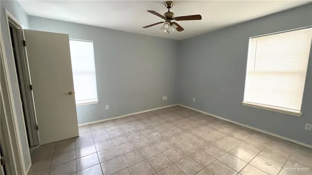 an empty room with a window and a fan