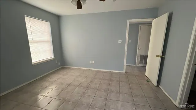 a view of an empty room with closet and a window