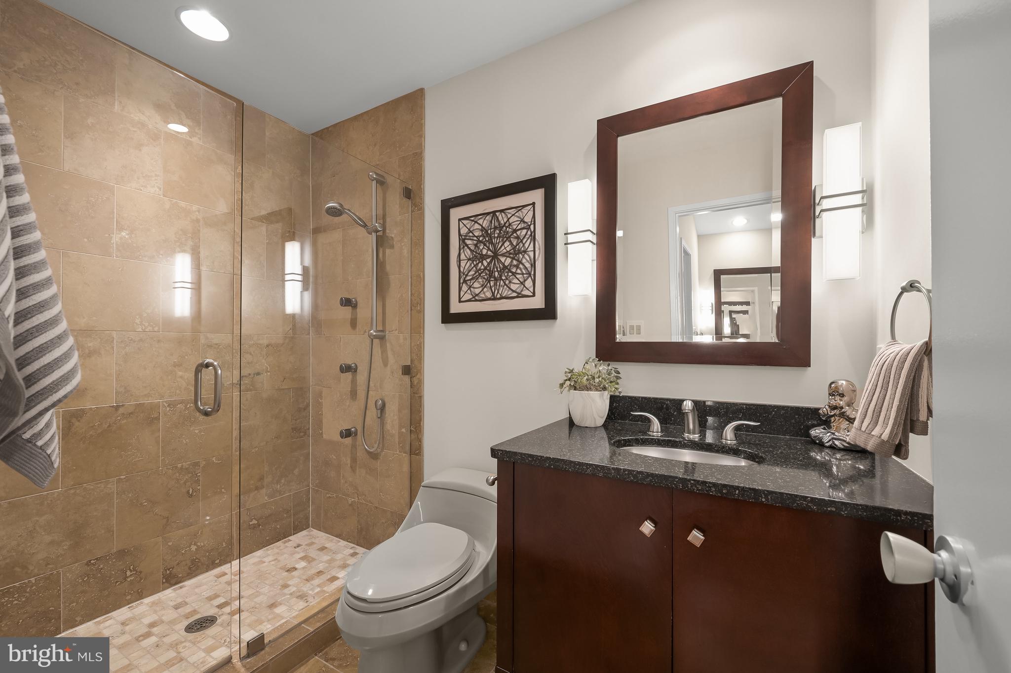 8805 Quiet Stream Court Potomac, MD 20854 - Photo 22 of 42 a bathroom with a granite countertop toilet sink and shower
