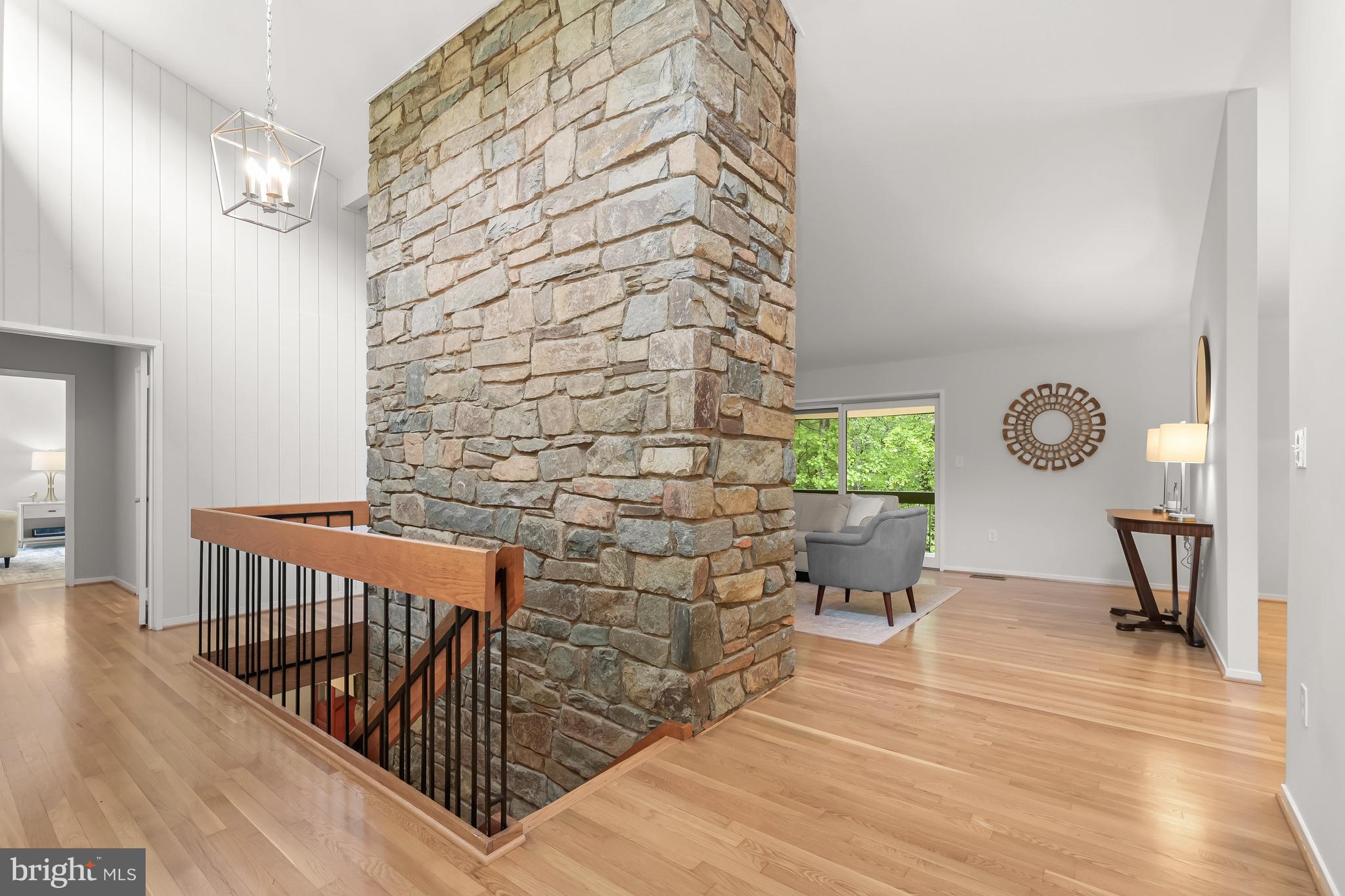 8805 Quiet Stream Court Potomac, MD 20854 - Photo 5 of 42 a view of a hallway with wooden floor and a chandelier