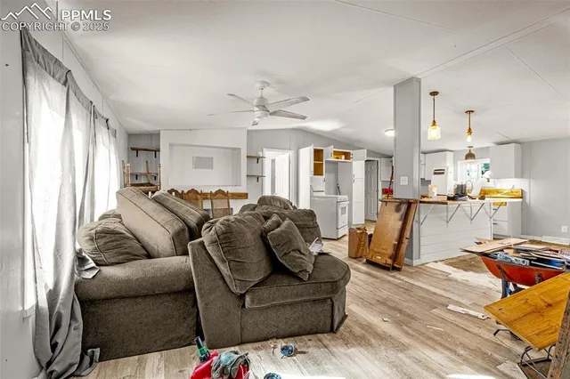 a living room with furniture and a view of kitchen