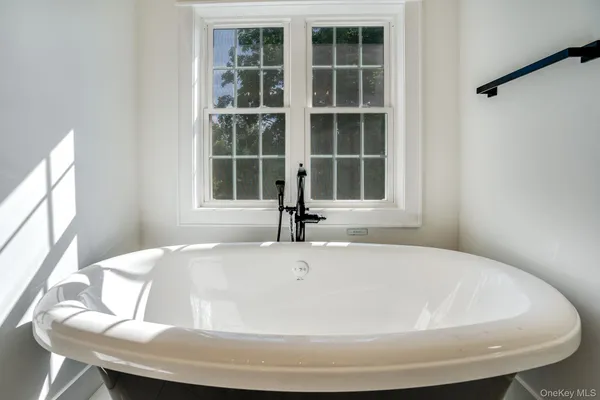 a white bath tub sitting next to a window