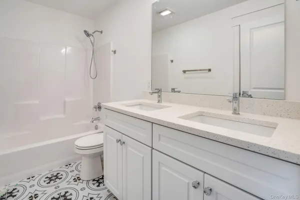 a bathroom with a sink a toilet and a large mirror