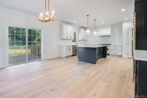 a large kitchen with kitchen island a large counter space a sink appliances and cabinets