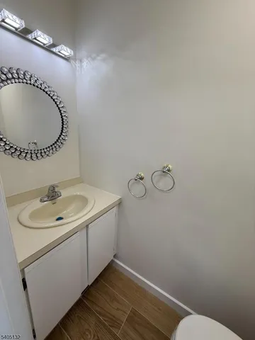 a bathroom with a granite countertop sink a toilet and a mirror