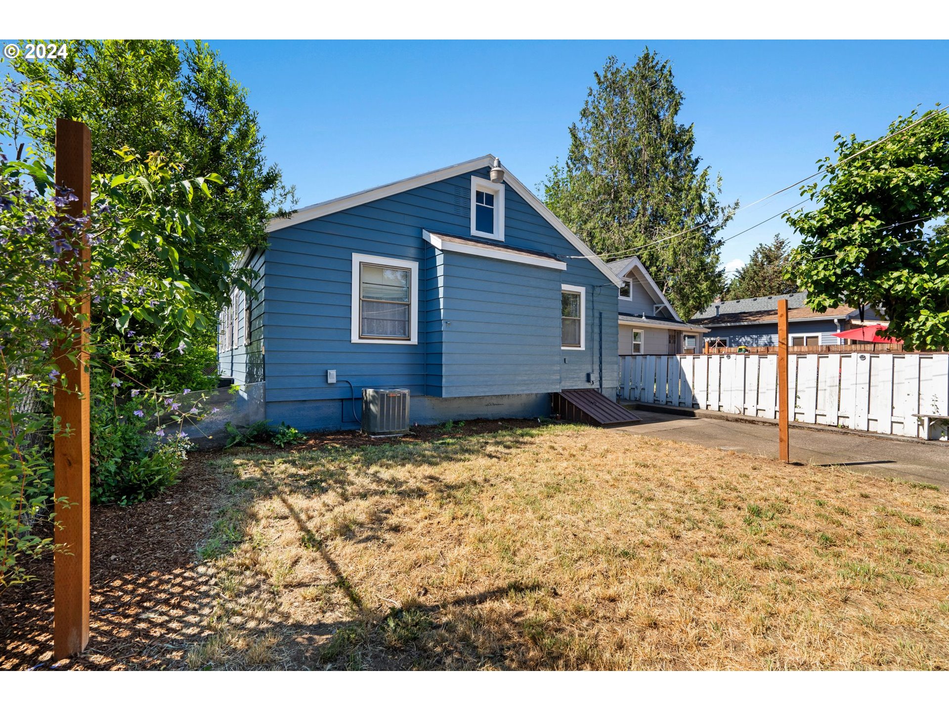 5811 Southeast Knight Street Portland, OR 97206 - Photo 8 of 9 a backyard of a house with wooden fence and large trees