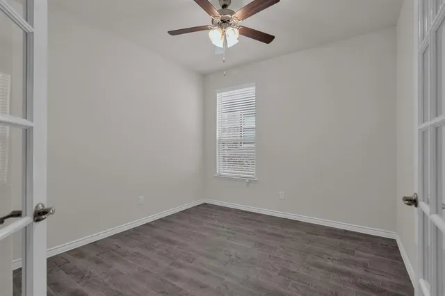 an empty room with a window and a fan