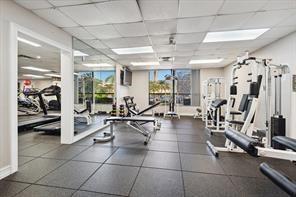 5054 Golfview Court, Unit 1514 Delray Beach, FL 33484 - Photo 25 of 27 a gym room with lots of gym equipment and windows