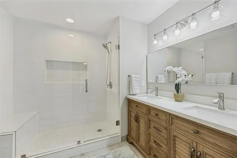 a bathroom with a shower sink and mirror