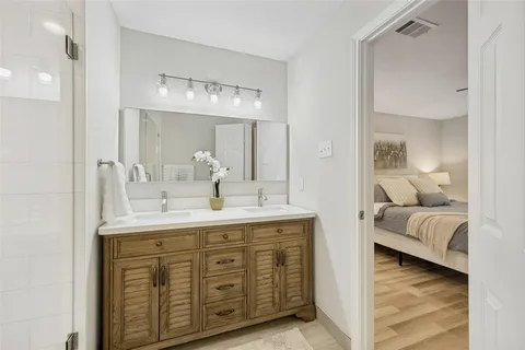 a en suite bathroom with a double vanity sink and a mirror