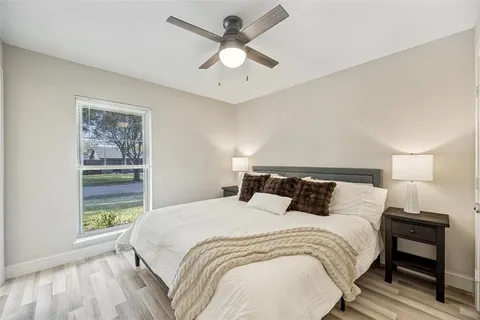 a bedroom with a large bed and a chandelier