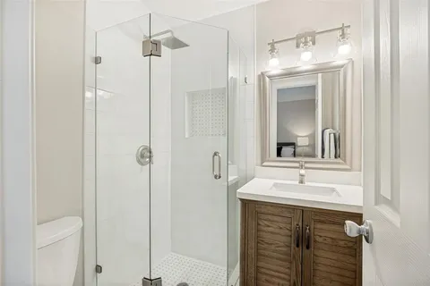 a bathroom with a sink a mirror a vanity and a shower
