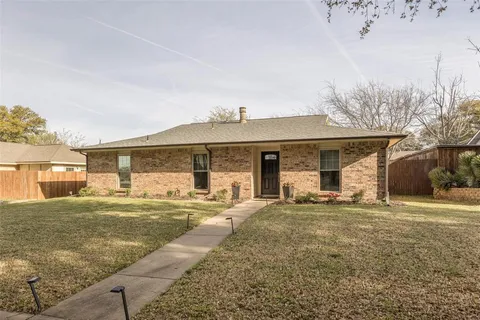 a front view of a house with a yard and seating space