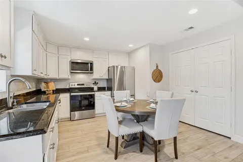 a kitchen with kitchen island granite countertop a sink appliances cabinets and a counter top space
