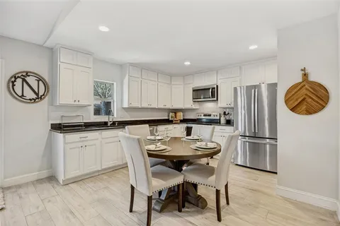 a kitchen with dining table and stainless steel appliances