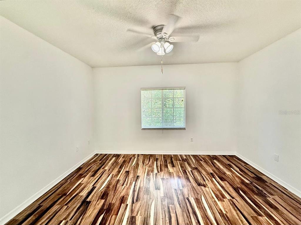 6014 Portsdale Place, Unit 202 Riverview, FL 33578 - Photo 12 of 29 an empty room with wooden floor chandelier fan and windows