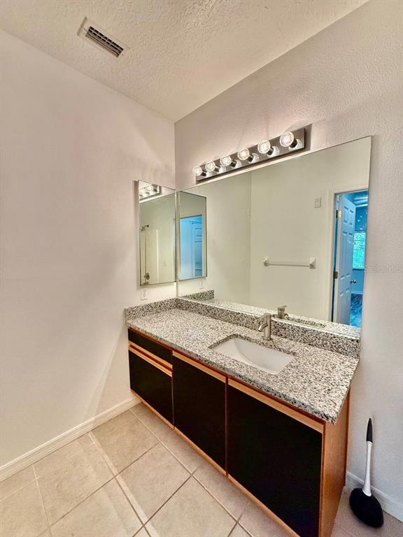 6014 Portsdale Place, Unit 202 Riverview, FL 33578 - Photo 16 of 29 a bathroom with a granite countertop sink and a mirror
