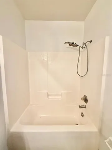 a bathroom with a bath tub with a shower