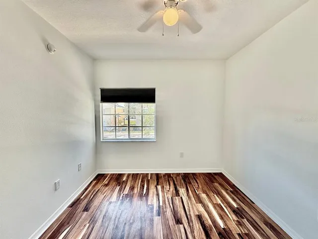 a view of a room with wooden floor and fan