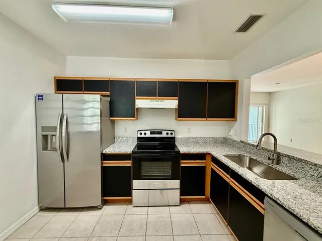 a kitchen with a sink stove and refrigerator