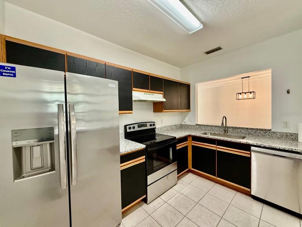 6014 Portsdale Place, Unit 202 Riverview, FL 33578 - Photo 5 of 29 a kitchen with stainless steel appliances granite countertop a sink and a refrigerator