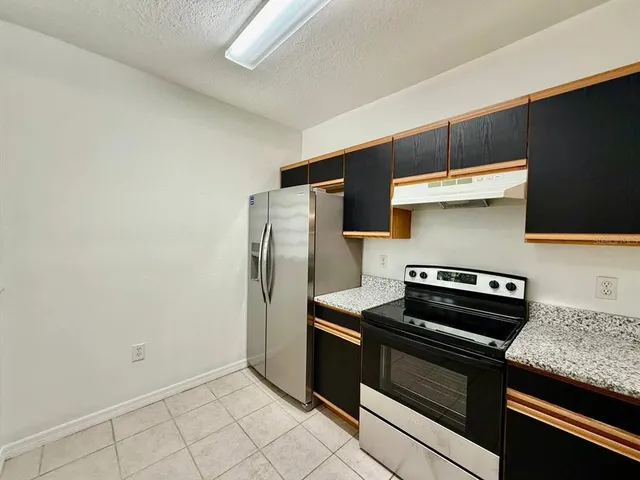 a kitchen with stainless steel appliances granite countertop a refrigerator and a stove