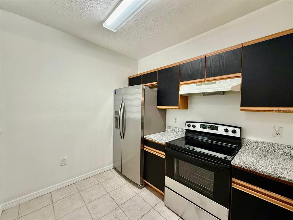 6014 Portsdale Place, Unit 202 Riverview, FL 33578 - Photo 6 of 29 a kitchen with stainless steel appliances granite countertop a refrigerator and a stove