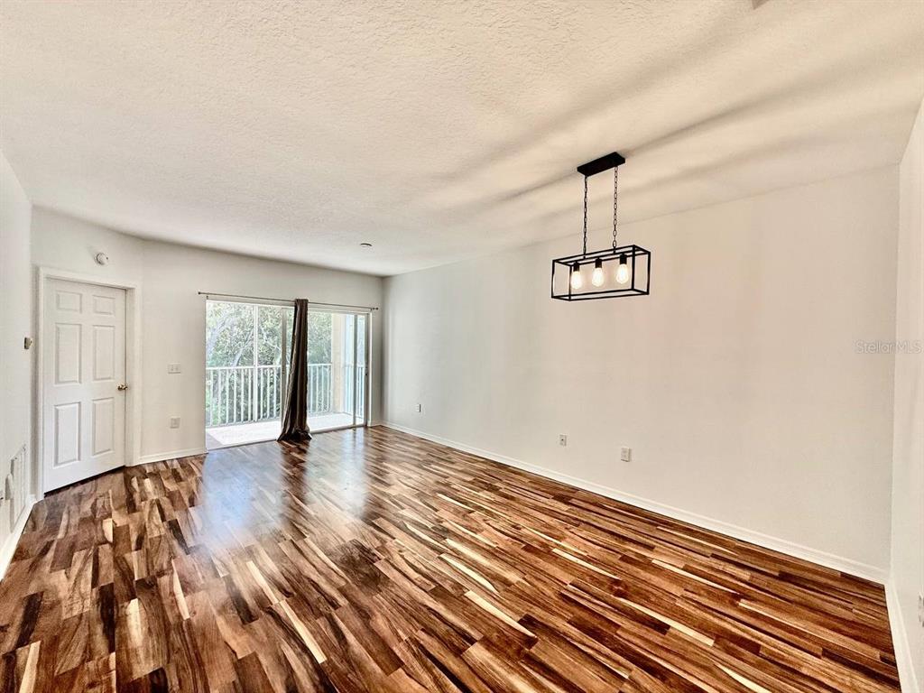 6014 Portsdale Place, Unit 202 Riverview, FL 33578 - Photo 7 of 29 a view of an empty room with wooden floor and a window