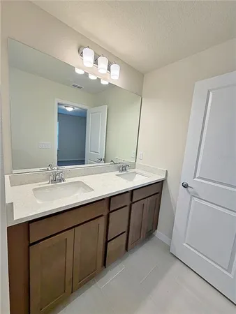 a bathroom with a granite countertop sink a large mirror and a vanity