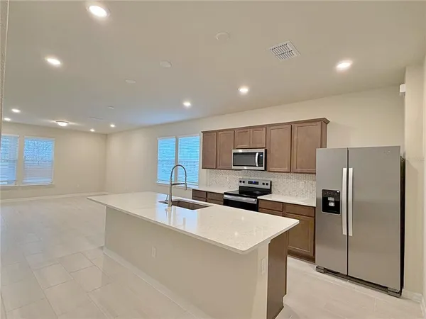 a kitchen with kitchen island a sink stainless steel appliances and cabinets