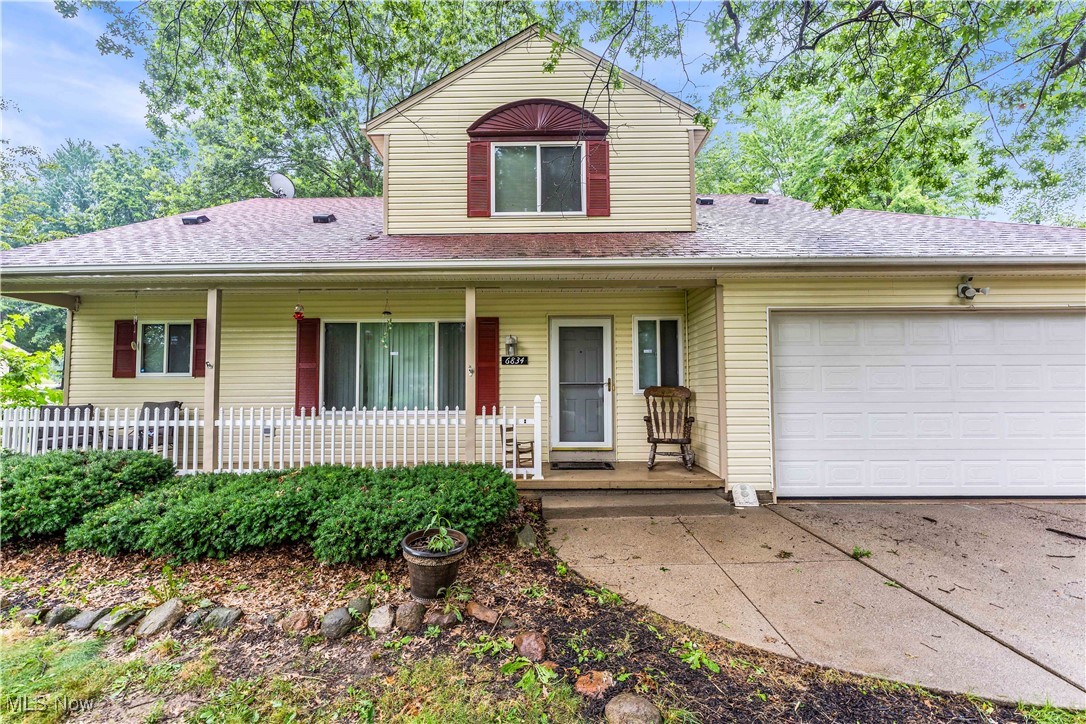 Traditional-style home featuring covered porch, a shingled roof, a garage, and concrete driveway