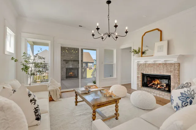a living room with furniture a chandelier and a fireplace