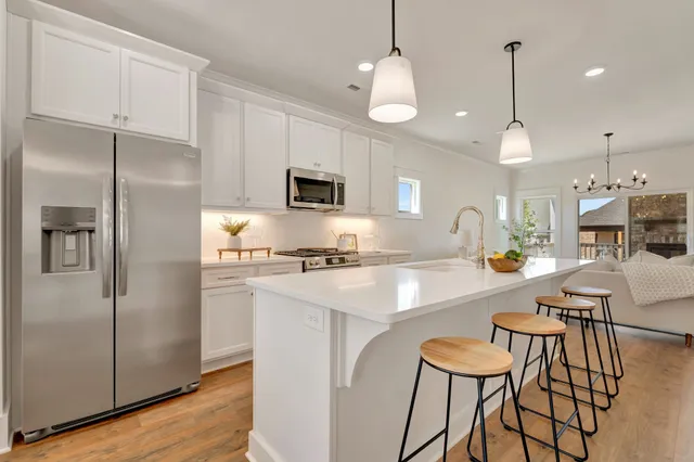 a living room with furniture a fireplace and a chandelier