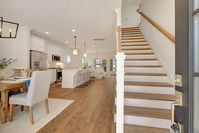 a dining room filled chandelier and kitchen view