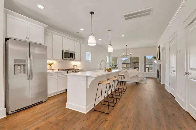 a kitchen with a stove a sink a microwave a dining table and chairs