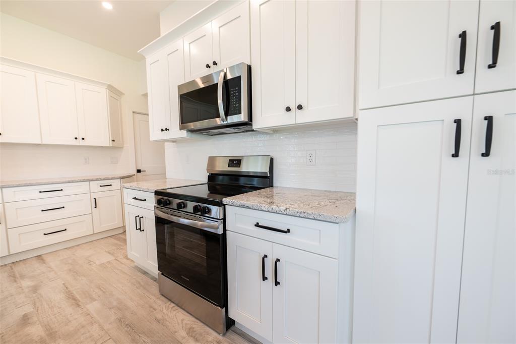 8846 Southwest Liverpool Road Arcadia, FL 34269 - Photo 11 of 29 a kitchen with white cabinets and stainless steel appliances