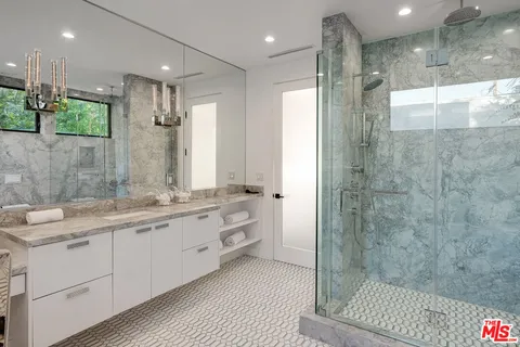 a bathroom with a double vanity sink mirror and shower