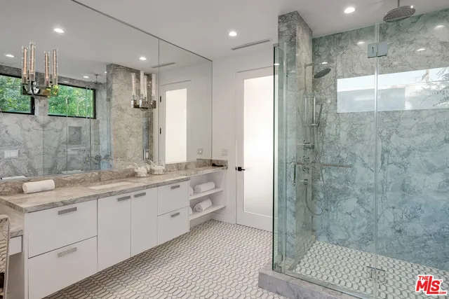 a bathroom with a double vanity sink mirror and shower