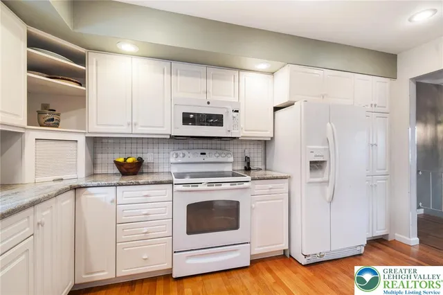 a kitchen with stainless steel appliances white cabinets and a refrigerator