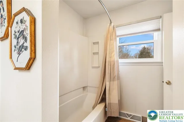a bathroom with a bathtub and a window