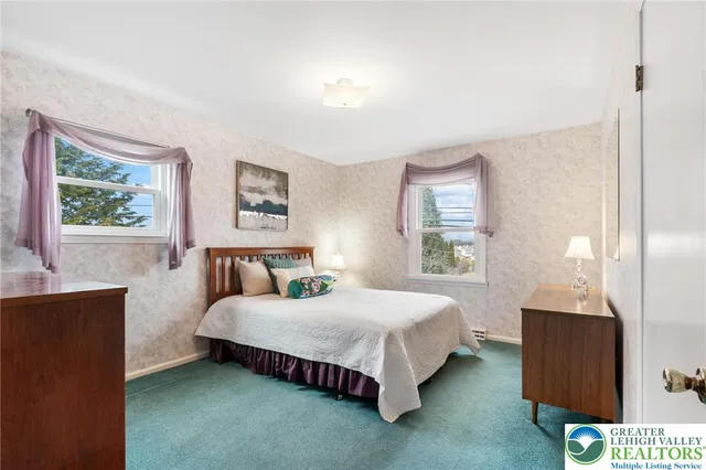 a bedroom with a bed a lamp on dresser and a window