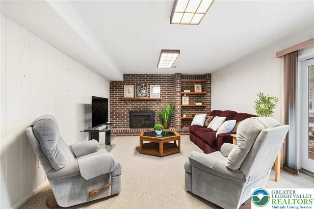 a living room with furniture a fireplace and a flat screen tv