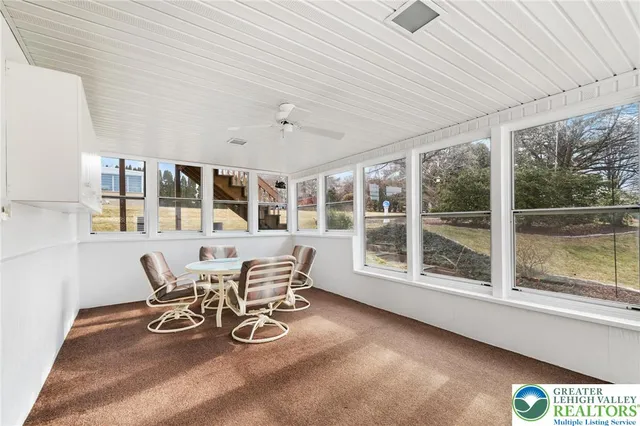 a view of a dining room with furniture large windows and wooden floor