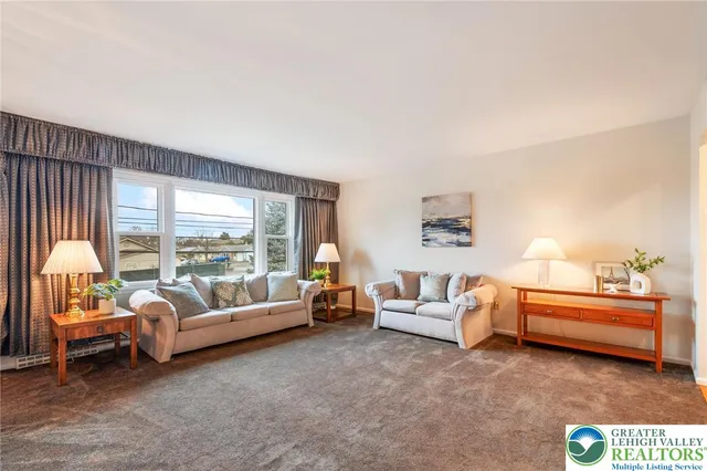 a bedroom with furniture and a large window