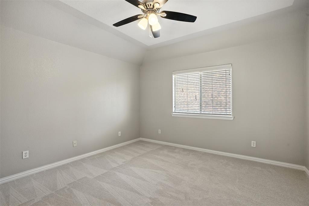 8220 Holliday Road Lantana, TX 76226 - Photo 37 of 40 Spacious room featuring a tray ceiling with a built-in ceiling fan, light-toned walls, and plush carpeting