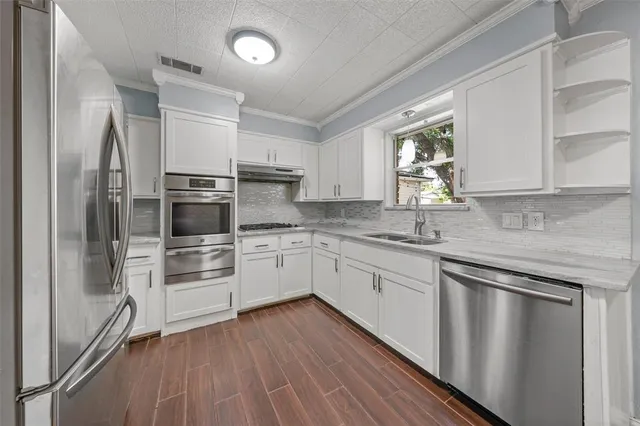 a kitchen with granite countertop white cabinets and stainless steel appliances