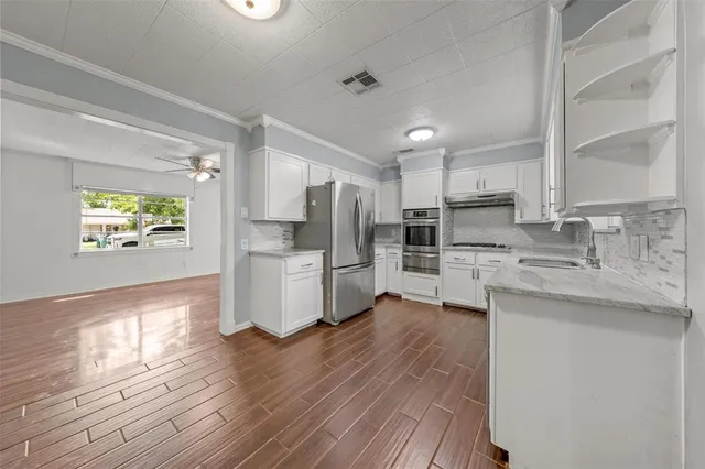 a kitchen with stainless steel appliances a refrigerator sink and microwave