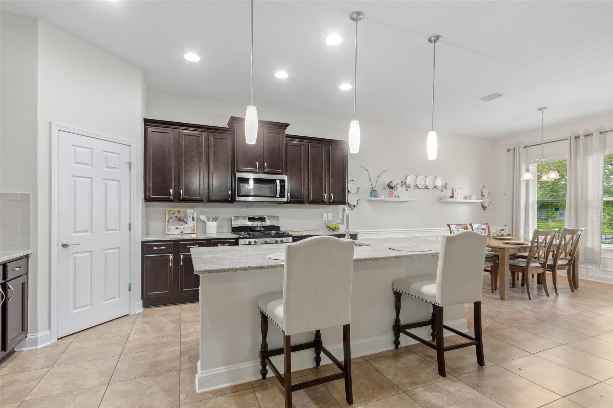 256 Vivian James Drive St. Augustine, FL 32092 - Photo 17 of 57 a kitchen with stainless steel appliances granite countertop a stove top oven a sink refrigerator and cabinets