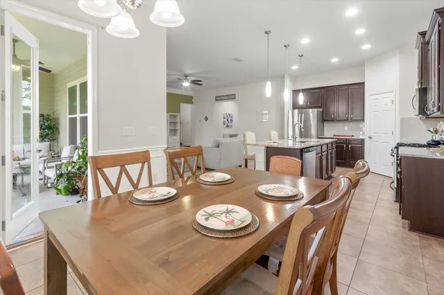 a kitchen with stainless steel appliances a sink a microwave a refrigerator and chairs