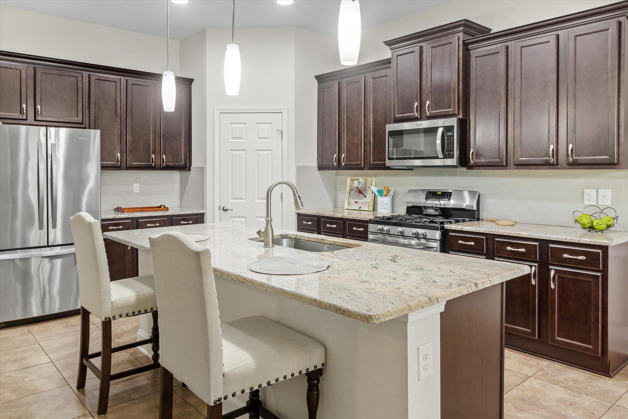256 Vivian James Drive St. Augustine, FL 32092 - Photo 21 of 57 a kitchen with stainless steel appliances a sink a microwave a refrigerator and chairs